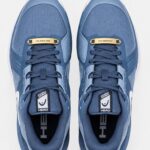 Gouden schoen tags met gravure op witte sneakers Gegraveerde veter tags in goud met naam Close-up van gouden schoenlabel met initialen Gouden schoen tags als luxe cadeau verpakt Sneaker accessoires in goud met persoonlijke tekst