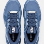 Gepersonaliseerde schoen tags zilver met gravure Zilveren schoen tags met naam op witte sneakers Close-up gravure op gepersonaliseerde veter tag Gepersonaliseerde schoen tags als cadeau verpakt Zilveren sneaker tags met initialen